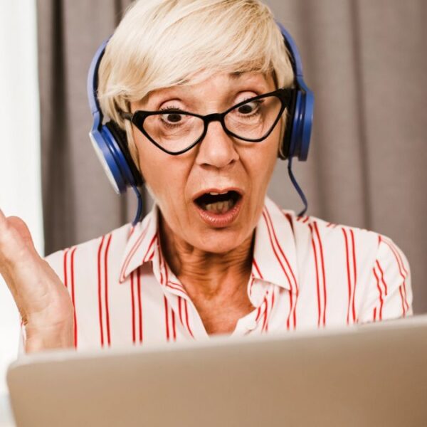 senior woman shocked headphones tablet