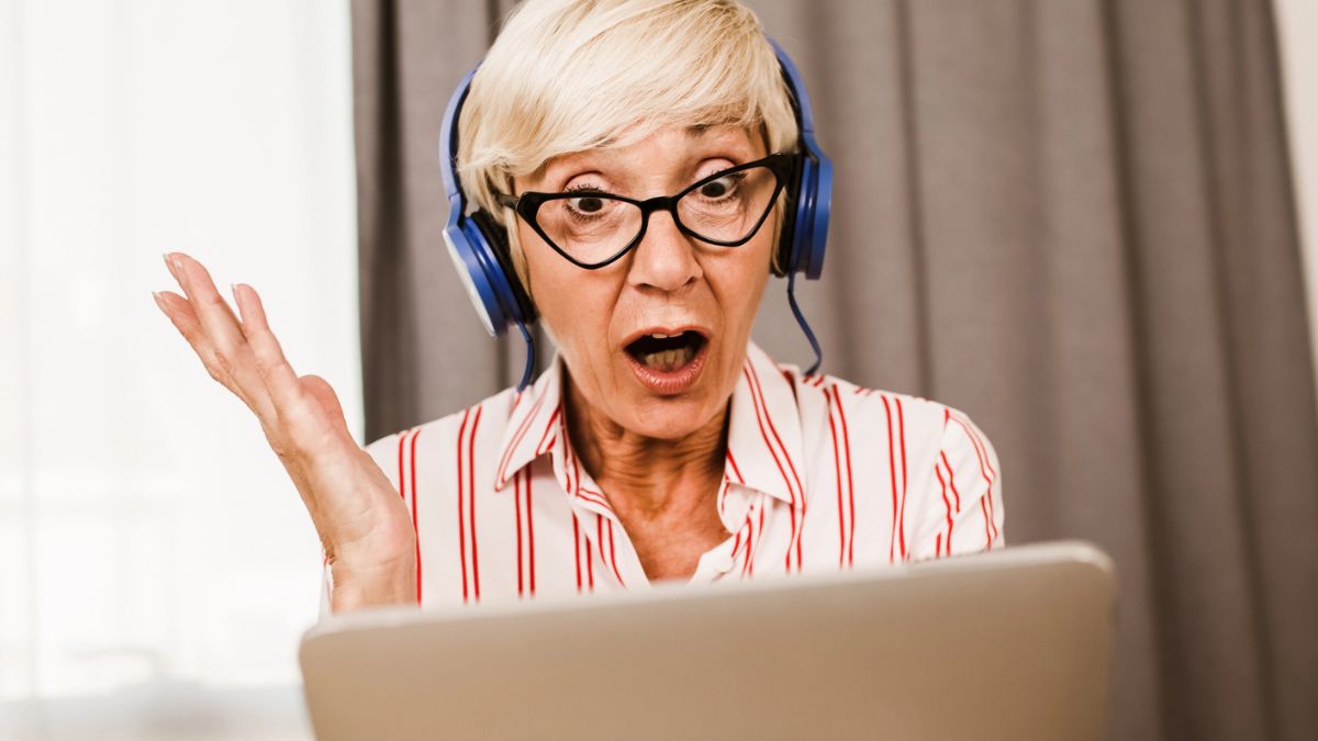 senior woman shocked headphones tablet