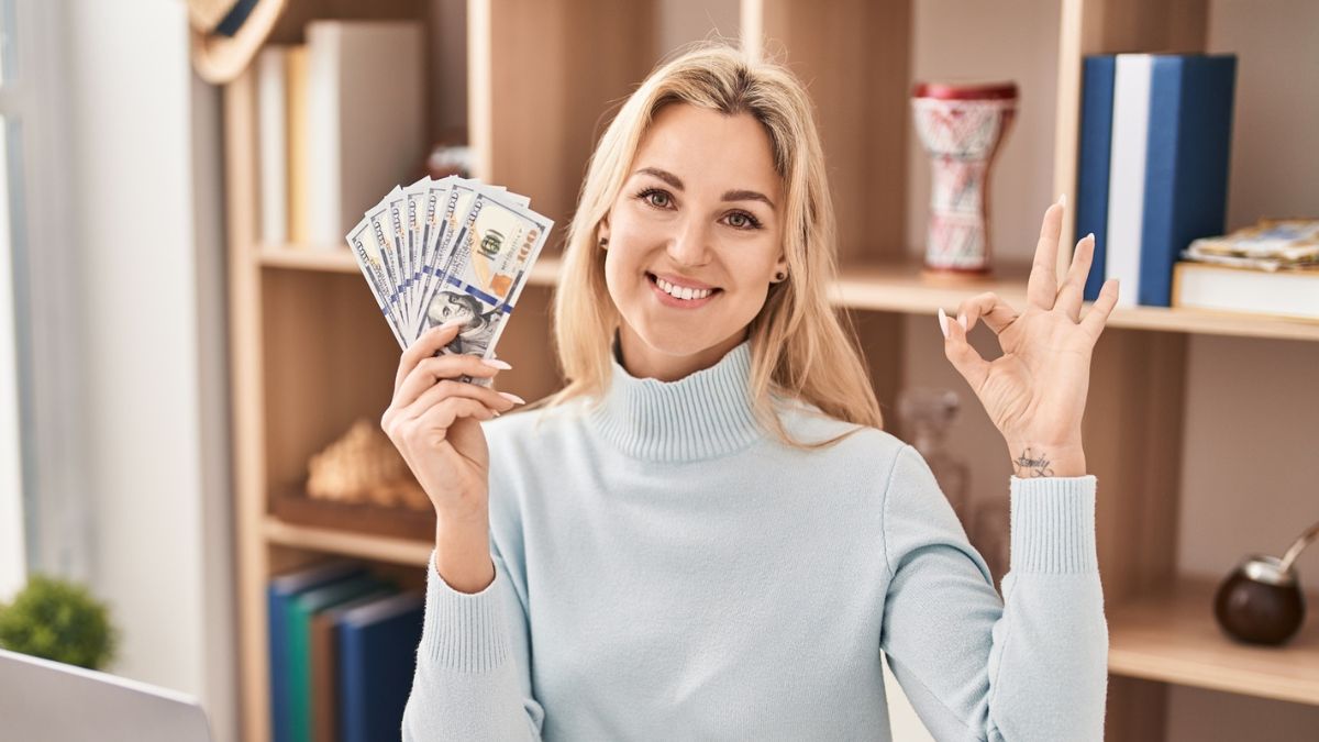 woman holding cash in office