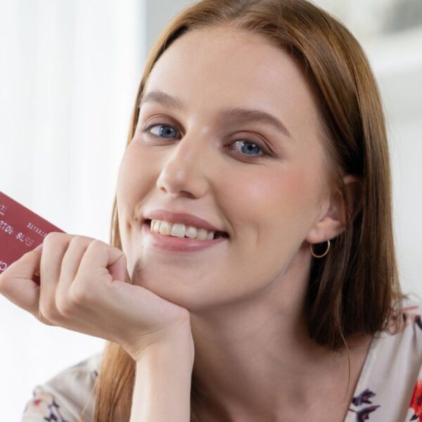 woman holding credit card red head