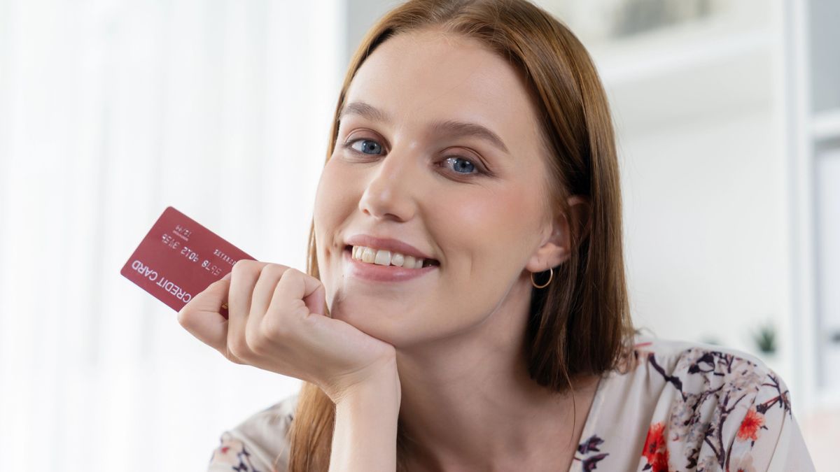 woman holding credit card red head