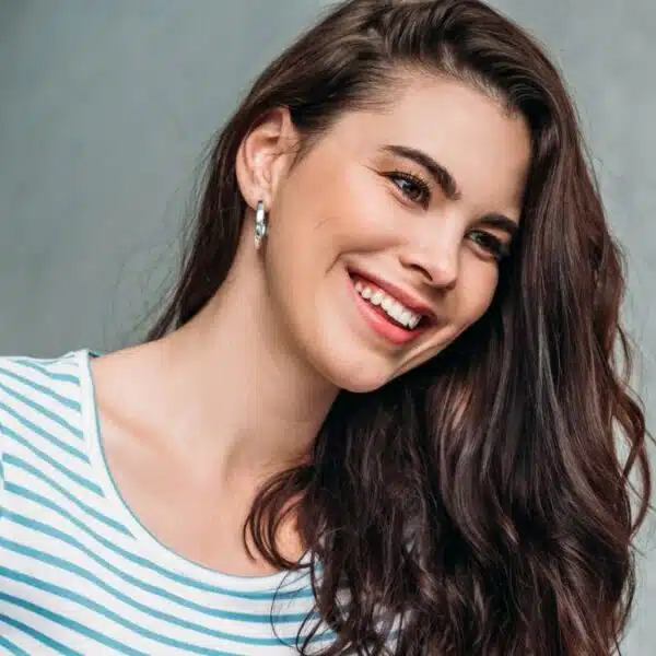 woman smiling at her laptop and ear rings