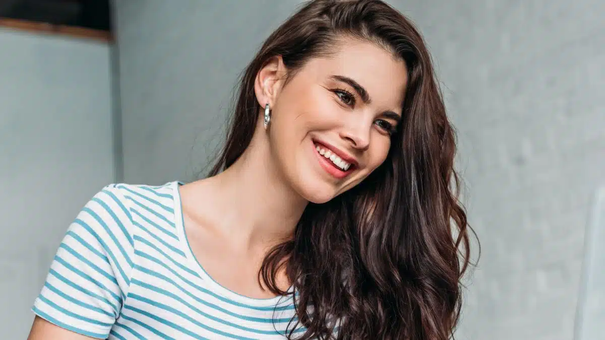 woman smiling at her laptop and ear rings