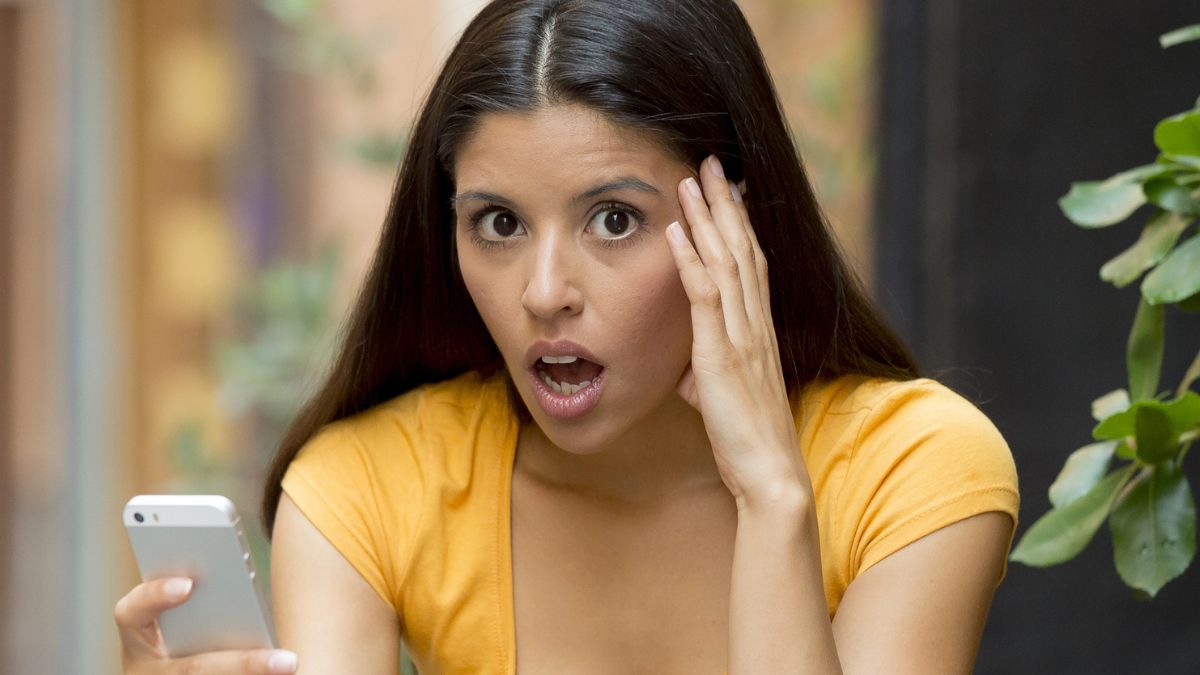 woman stunned looking at her phone