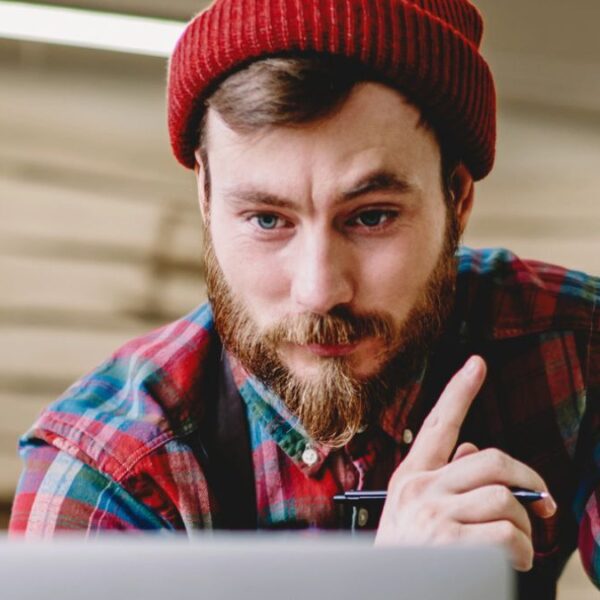 man beanie on a laptop