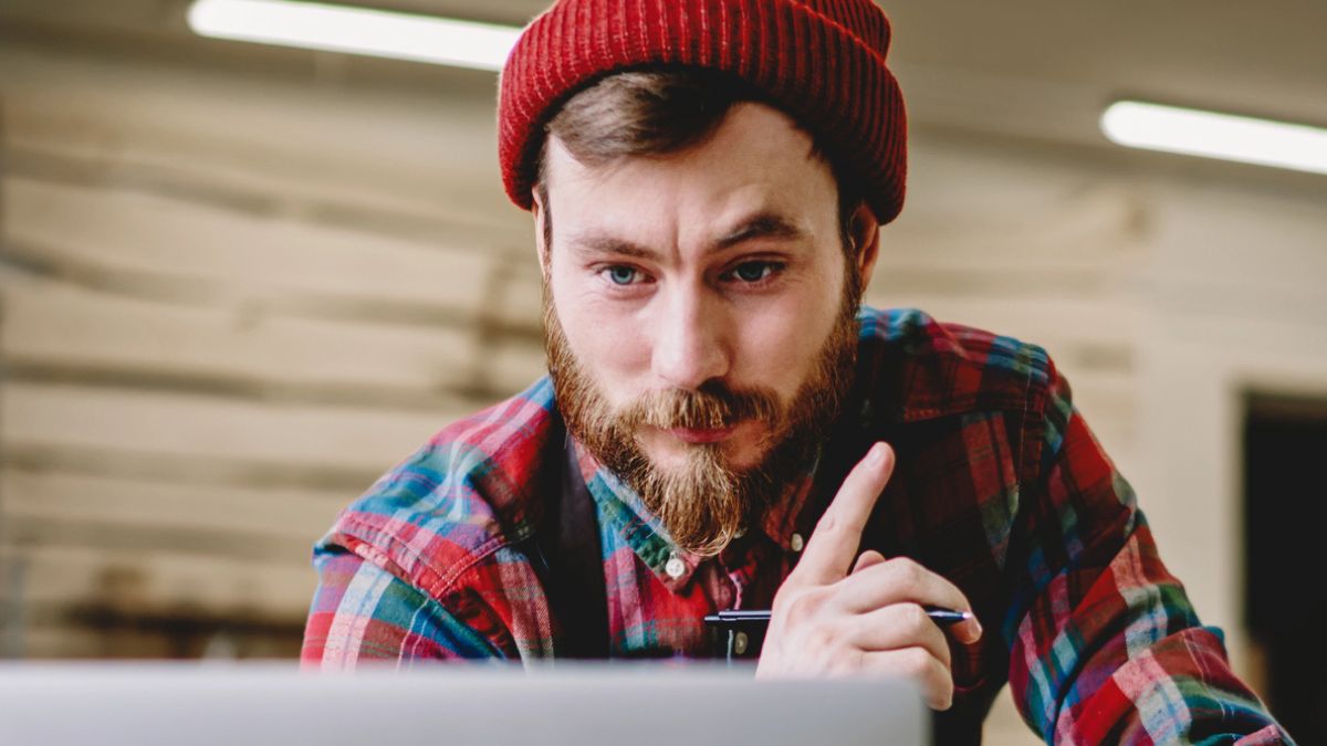man beanie on a laptop
