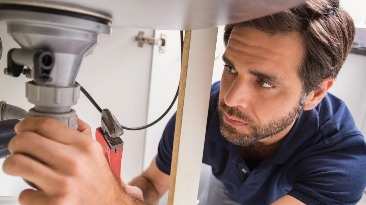 man fixing sink drain