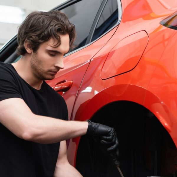 man working on a red car