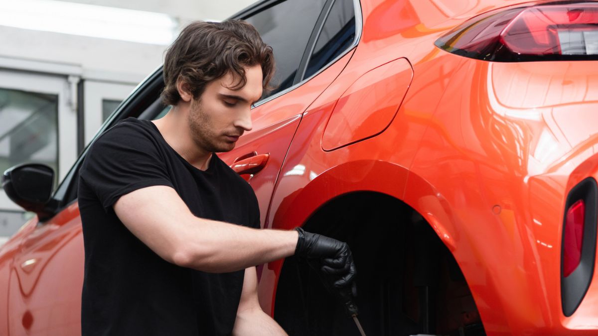 man working on a red car