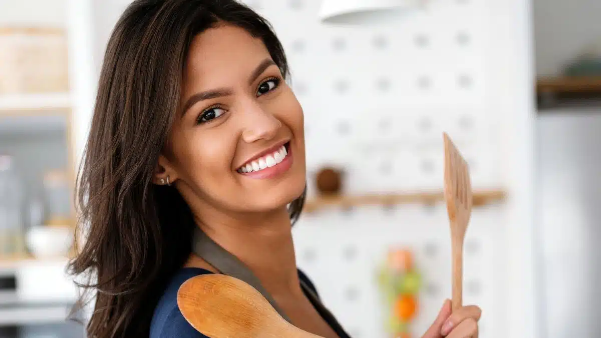 woman cooking with spoons smile