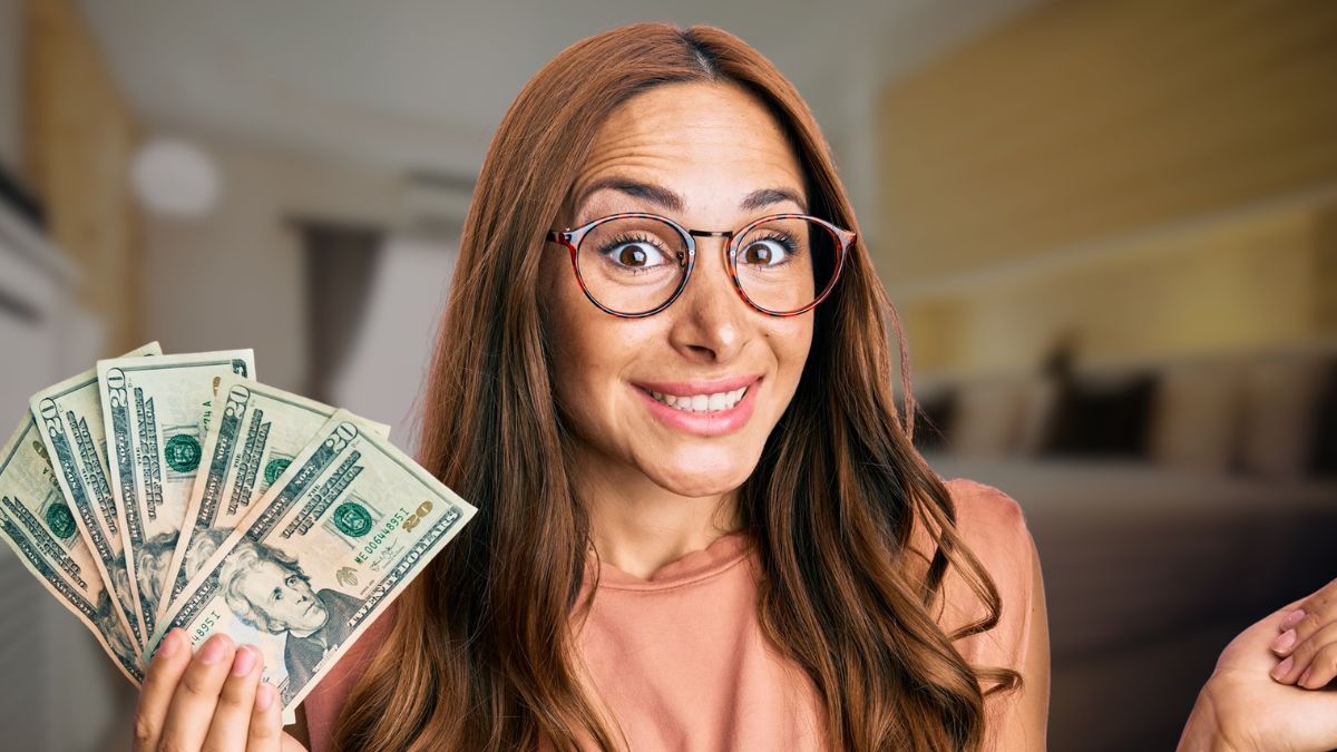 woman glasses holding cash in her room