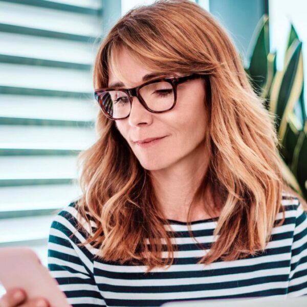 woman glasses looking at her phone