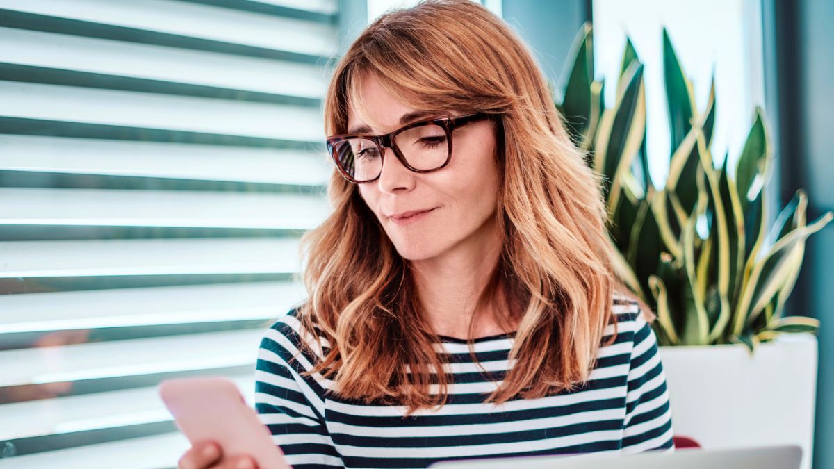 woman glasses looking at her phone