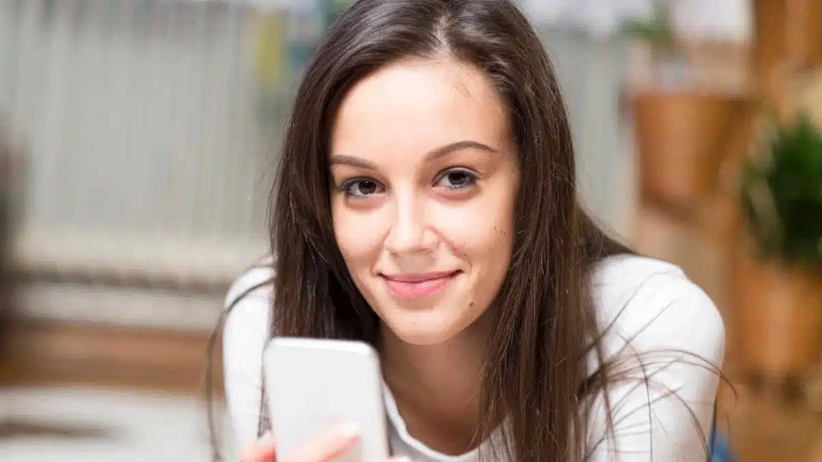 woman holding her phone smiling