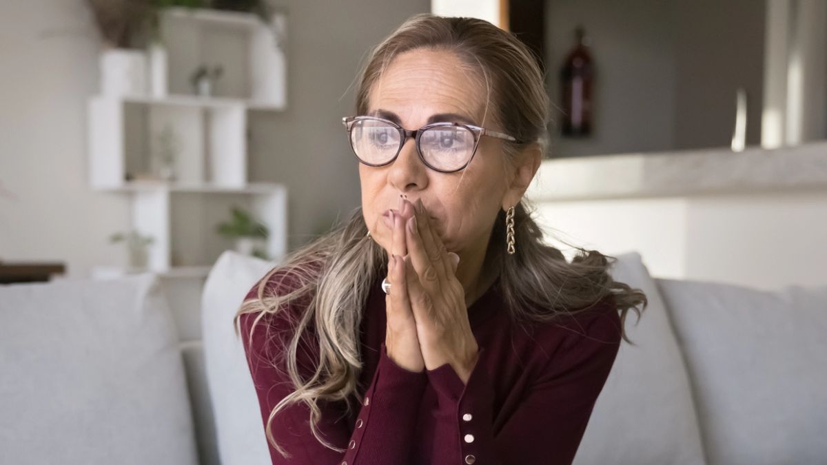 woman looking at the window in her lviing room