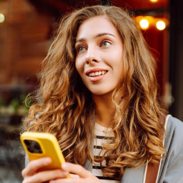 woman looking on her phone smiling