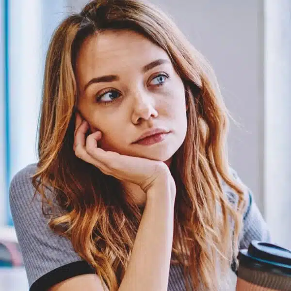woman thinking holding a coffee cup