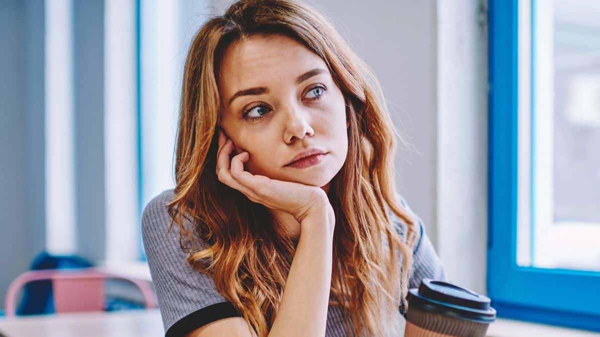 woman thinking holding a coffee cup