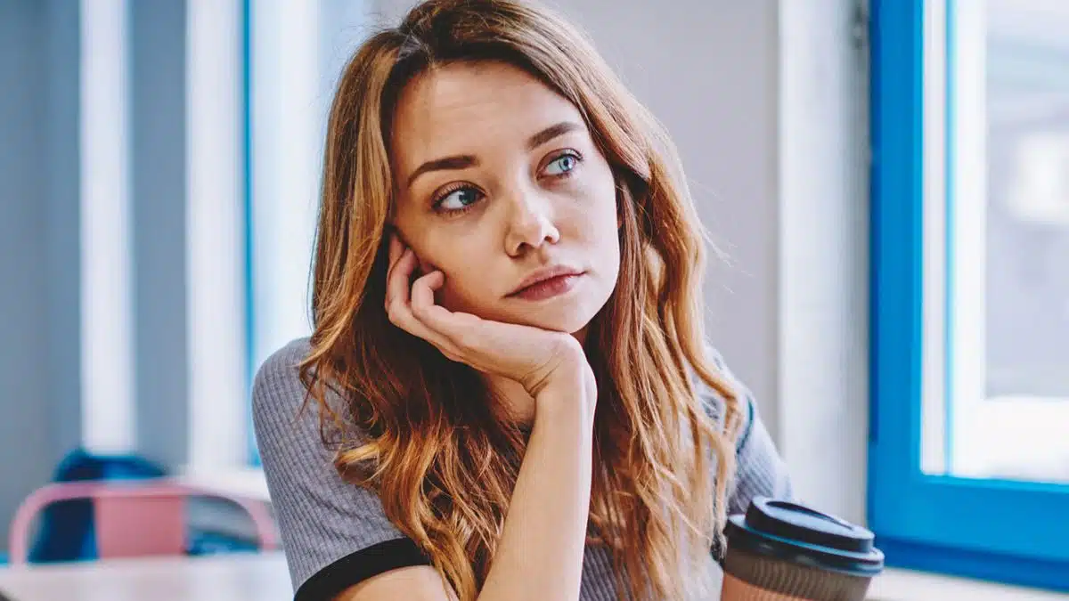 woman thinking holding a coffee cup