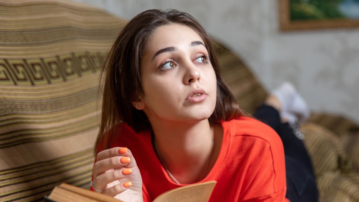 woman thinking reading a book