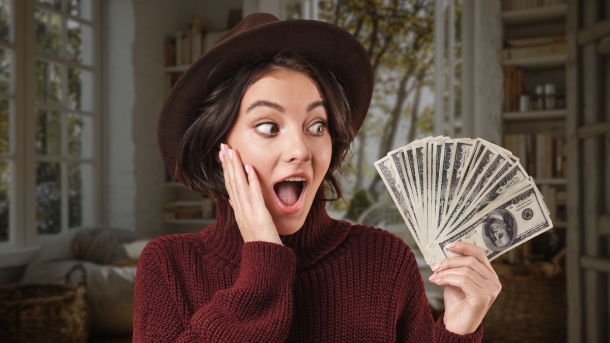 woman with hat holding cash