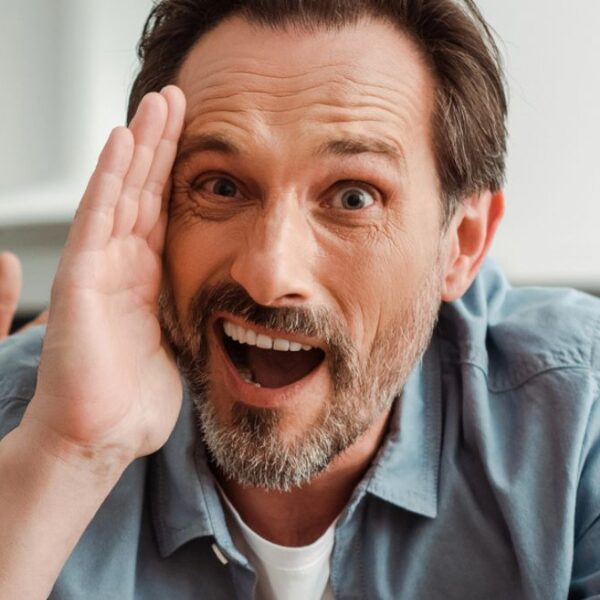 man shocked hand in face