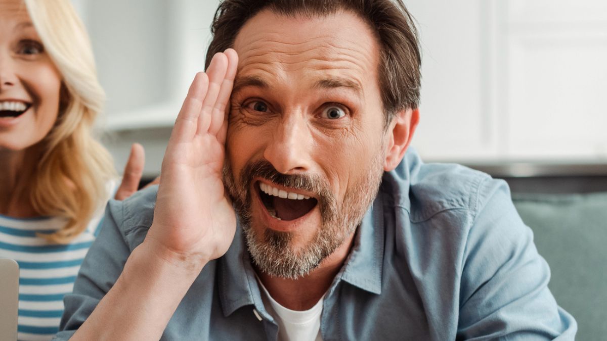 man shocked hand in face