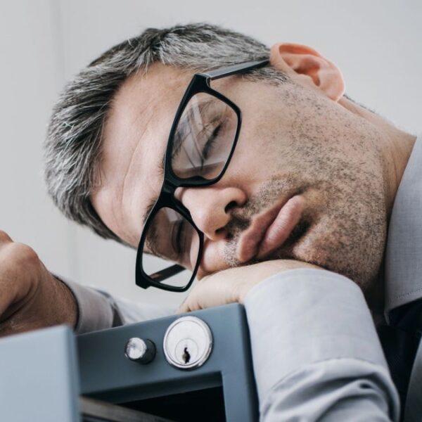 man sleeping on filing cabinet