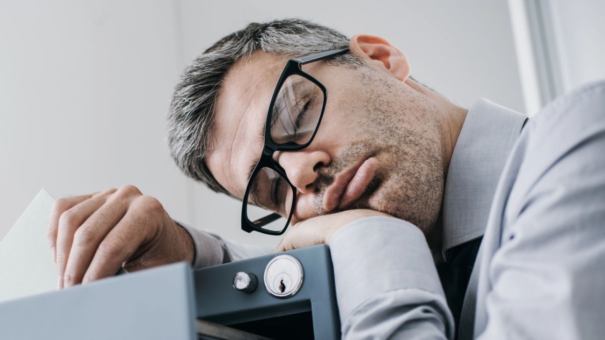 man sleeping on filing cabinet