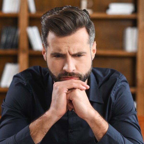man thiking sitting on couch