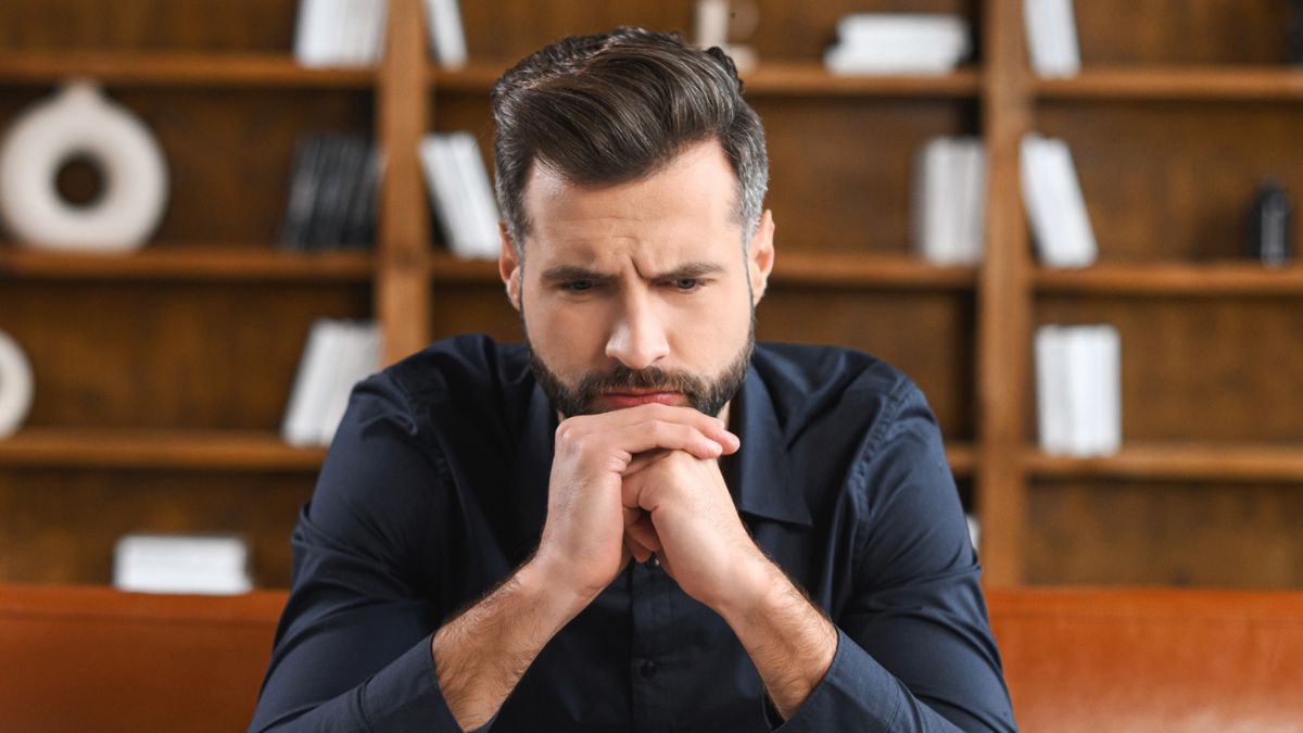 man thiking sitting on couch