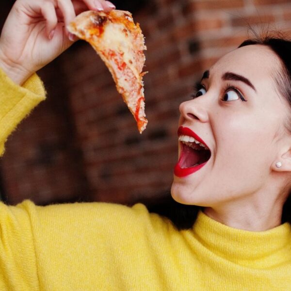 woman eating pizza at restaurant