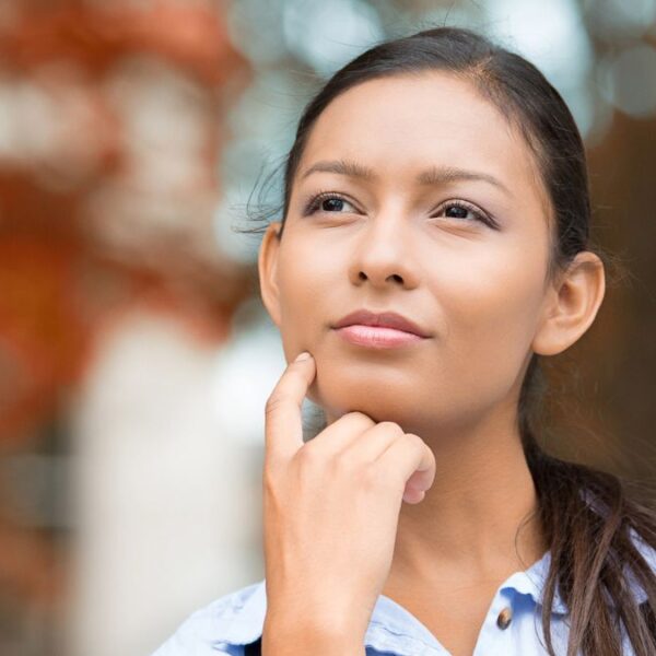 woman thinking in front of leaves