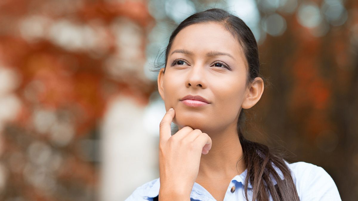 woman thinking in front of leaves