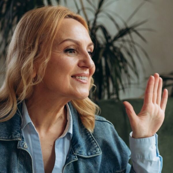woman waving on her laptop