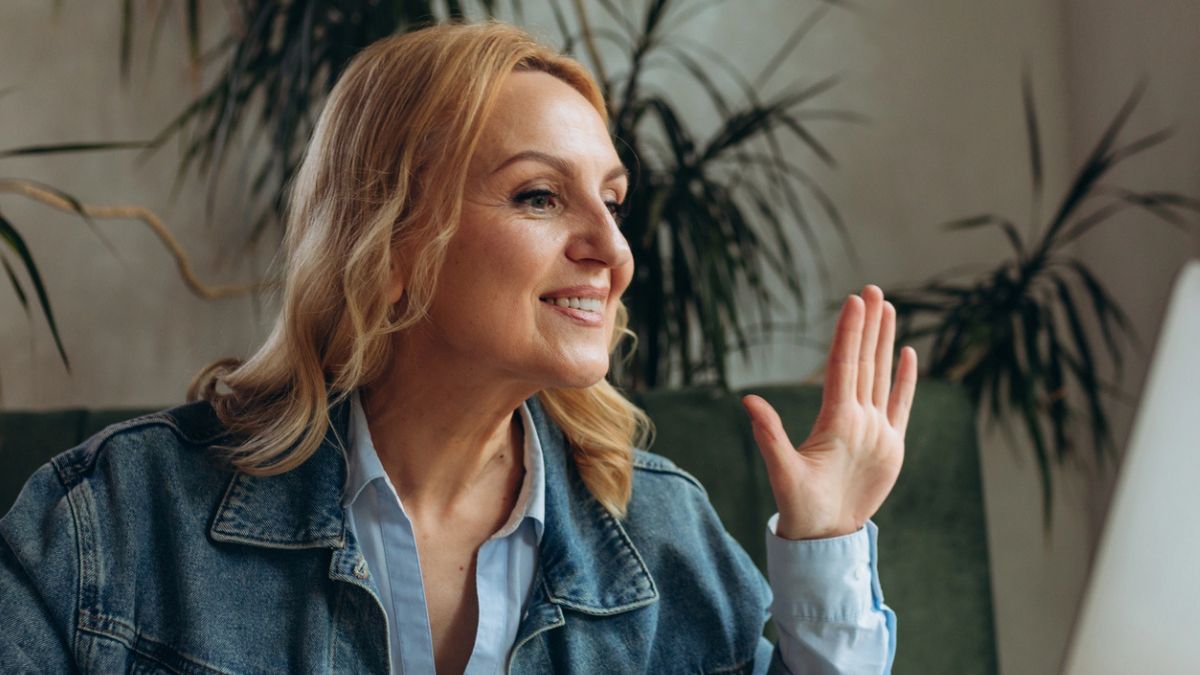 woman waving on her laptop