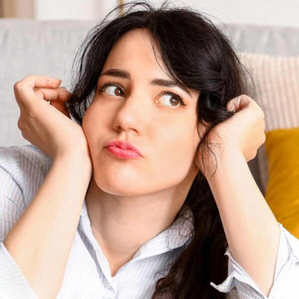 woman worried sitting in front her couch