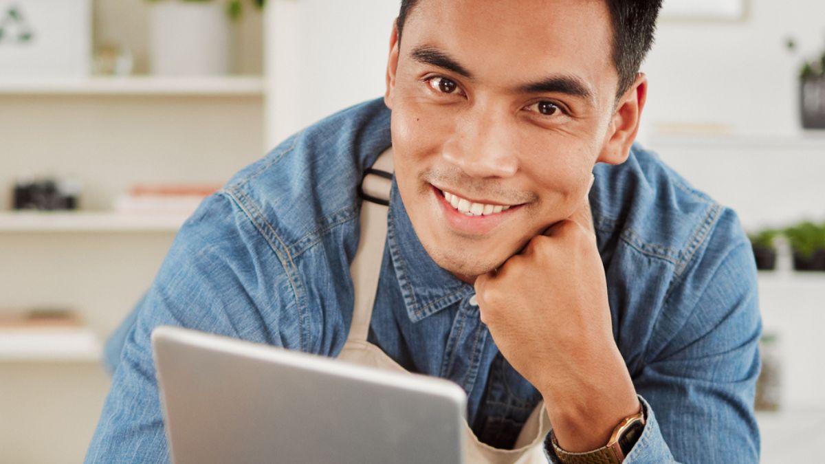 man apron looking at his tablet
