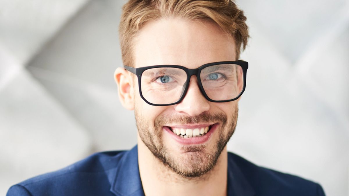 man suit glasses siting in office happy