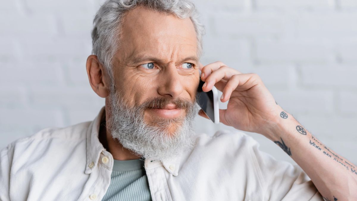 mature man grey with a phone