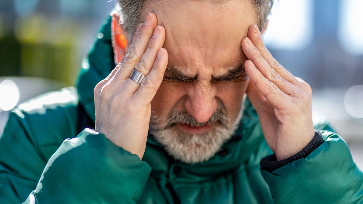senior man jacket headache