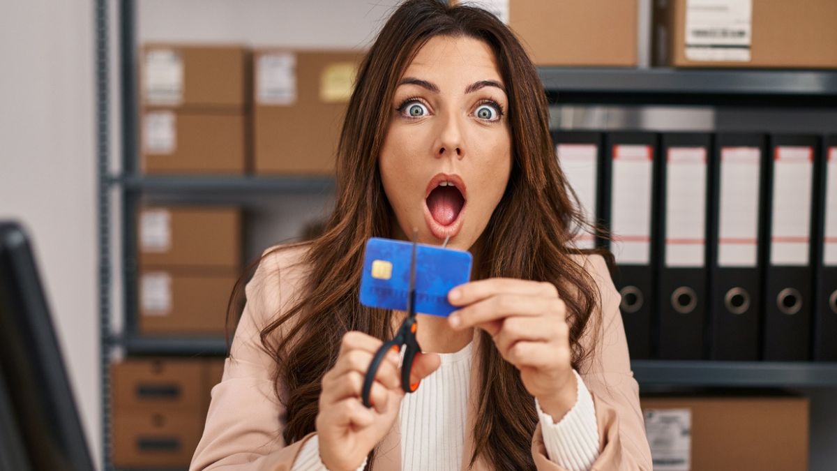 woman cutting credit card