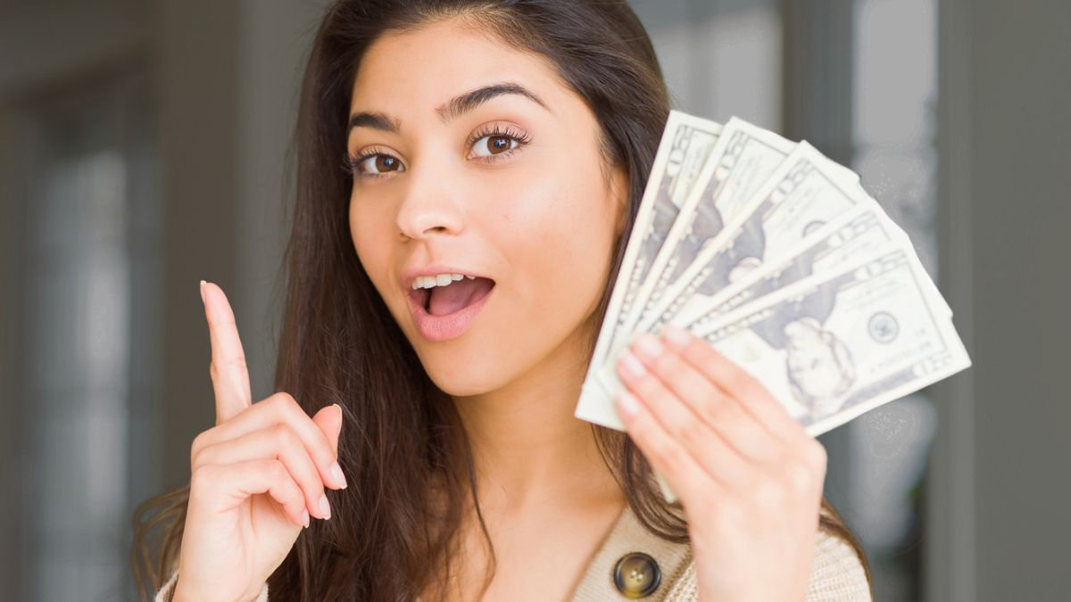 woman holding cash and pointing
