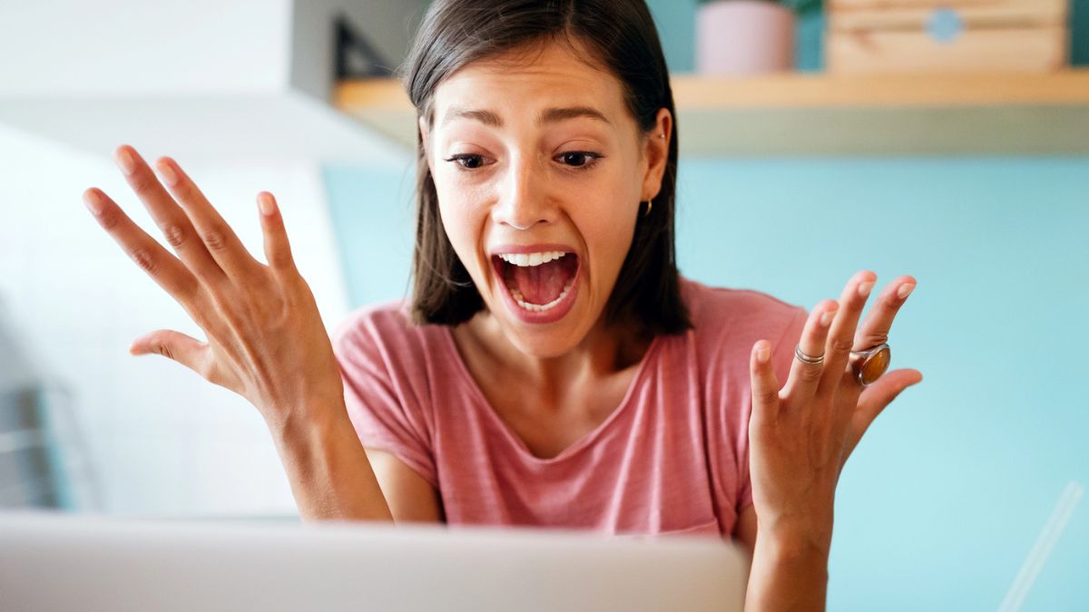 woman in shock surprised at her laptop