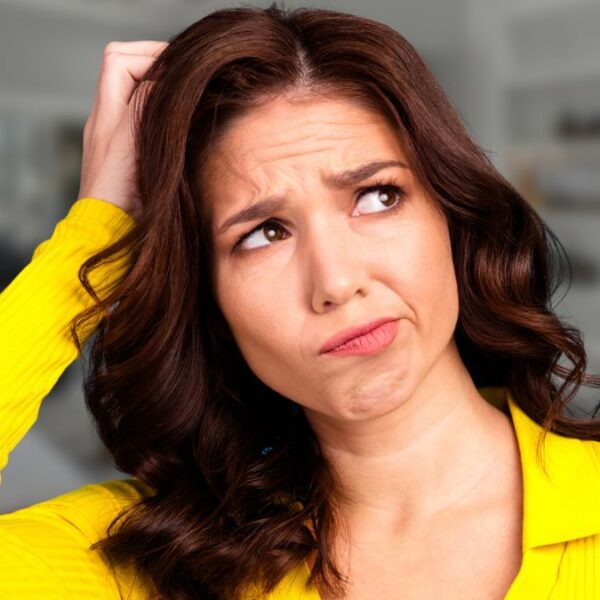 woman scratching her head in living room