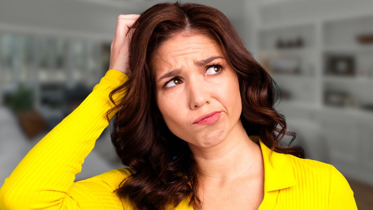 woman scratching her head in living room