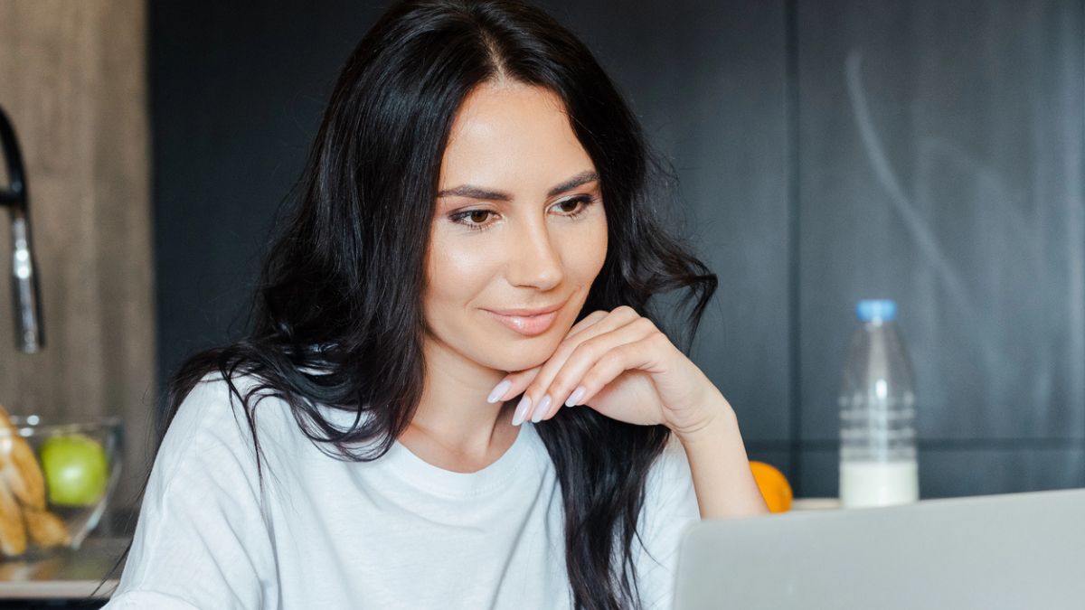 woman sitting at a kithcen laptop